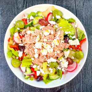 Aerial view of white bowl with Greek tuna salad.