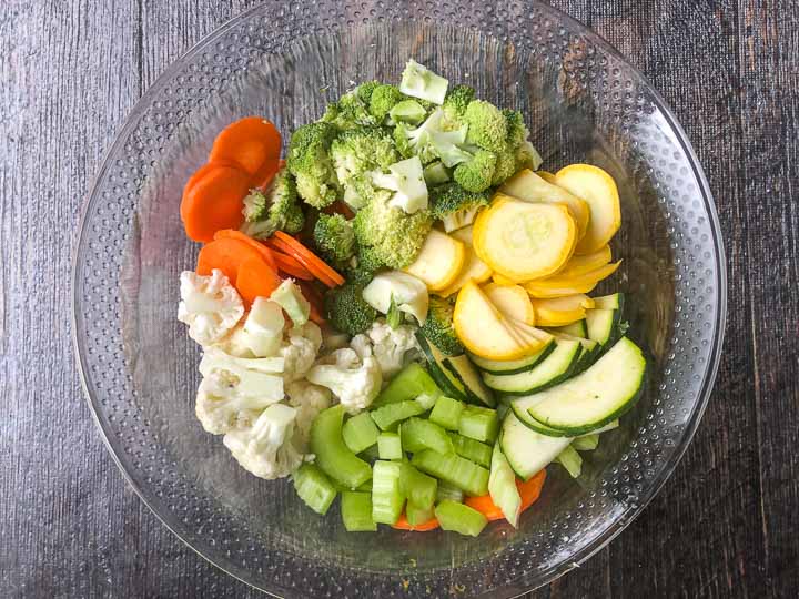glass bowl with cut raw vegetables for soup