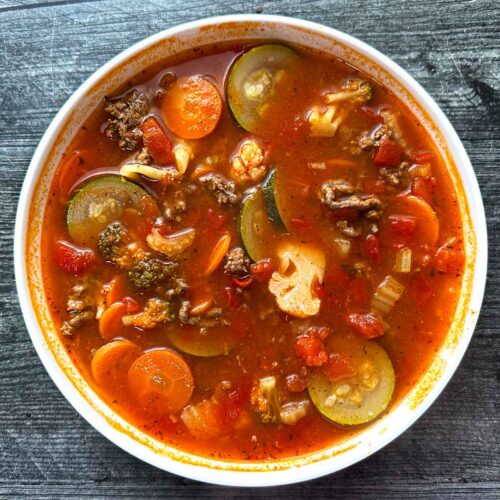 A white bowl of low carb Italian vegetable soup.