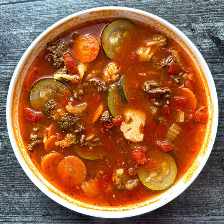 A white bowl of low carb Italian vegetable soup.