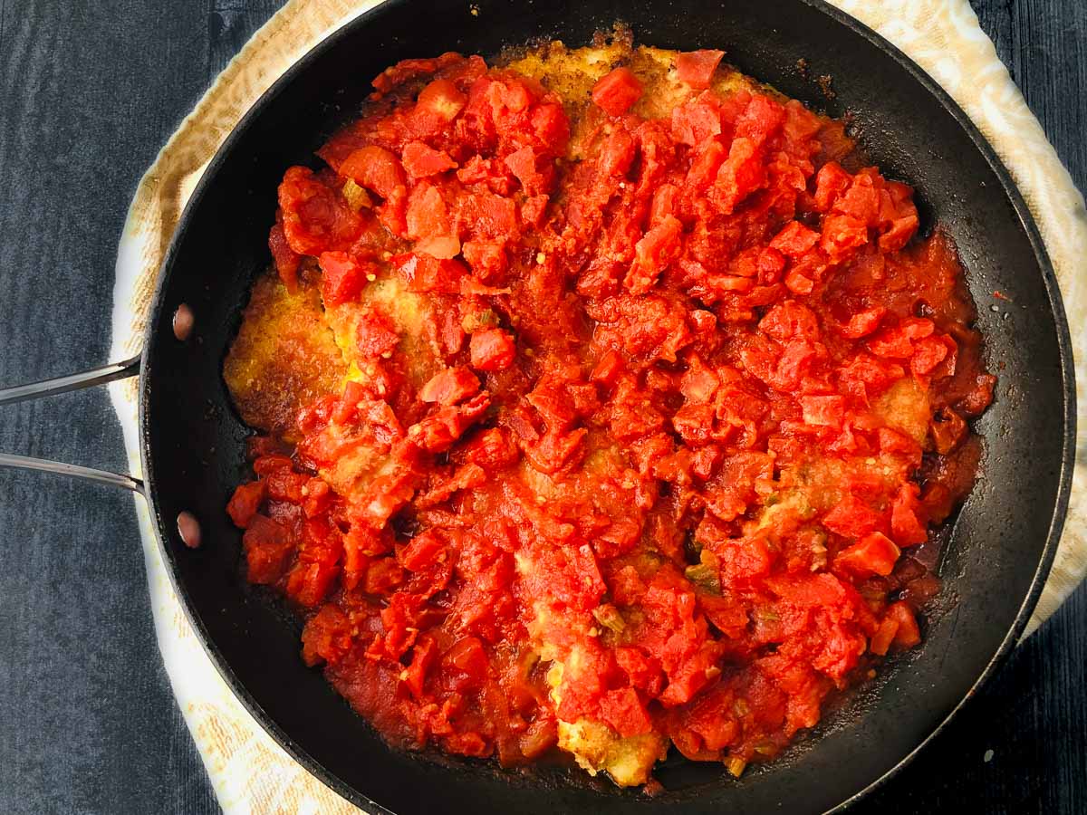 pan with fried tilapia and stewed tomatoes