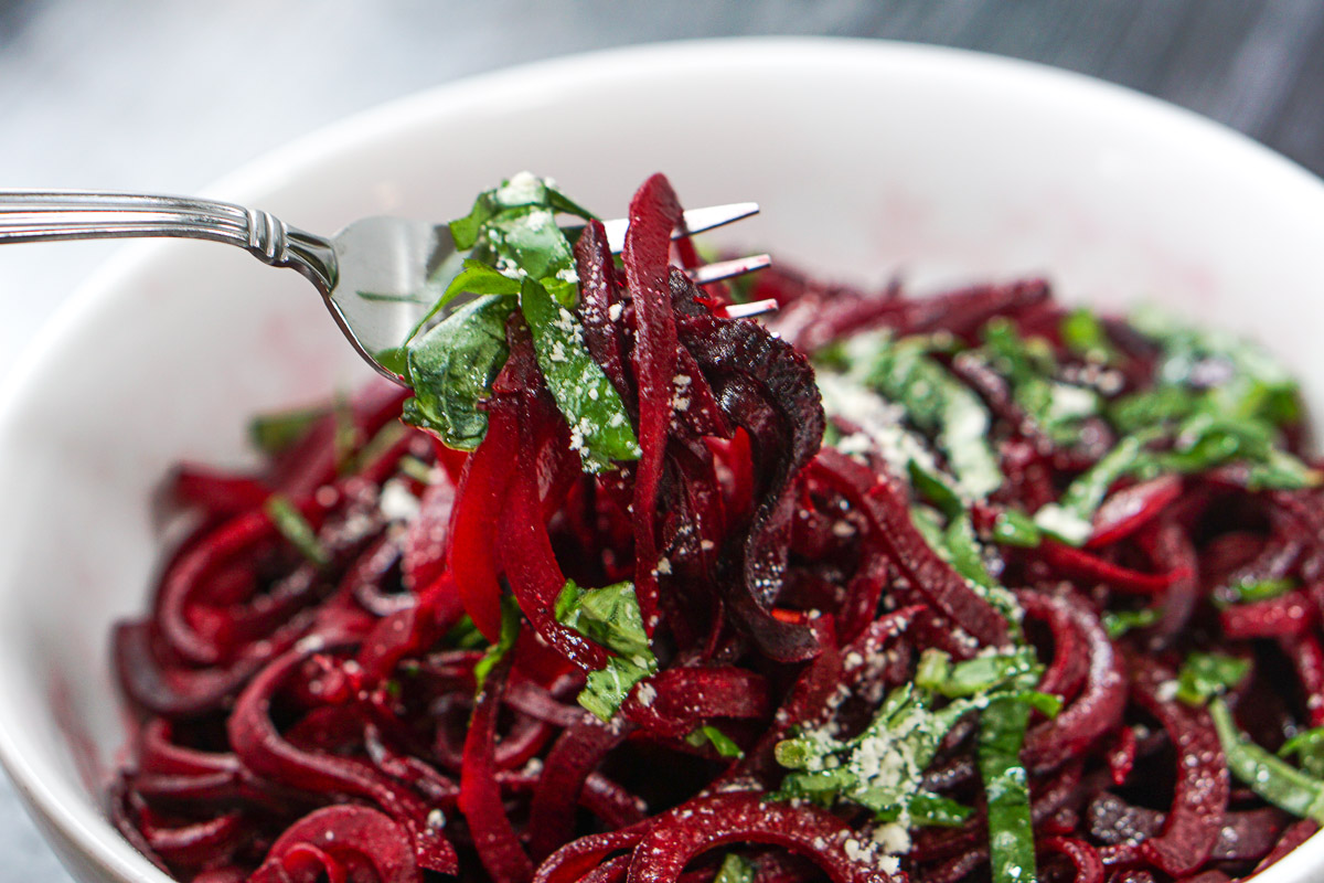 a forkful of vegetable pasta made from beets
