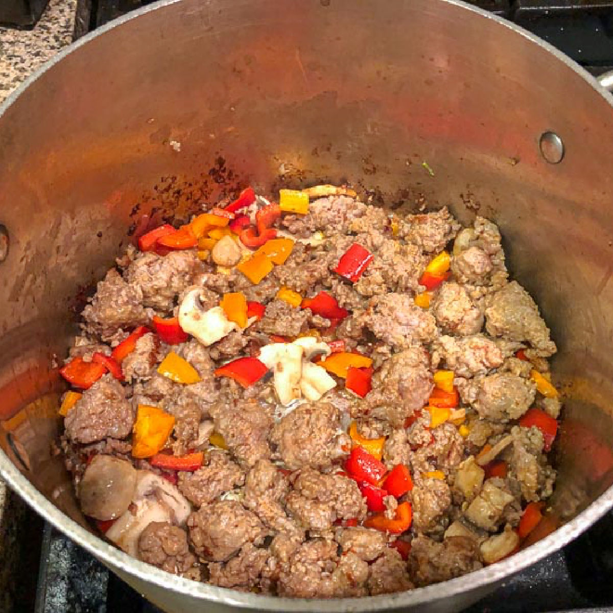 Closeup of the soup pot with the browned sausage and veggies.