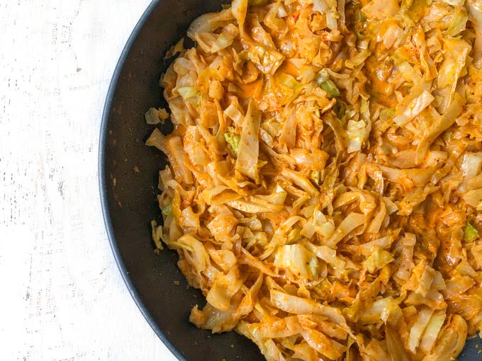 skillet with cooked low carb red curry cabbage noodles