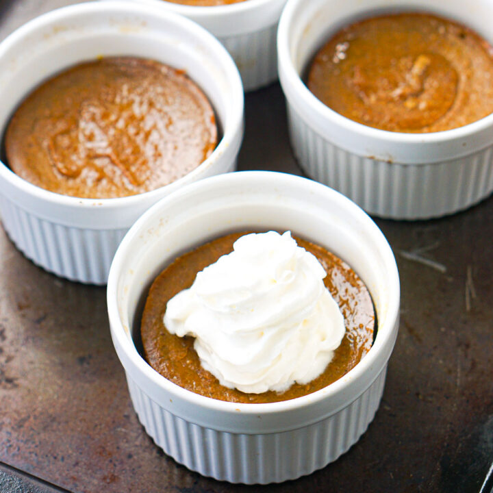 3 ramekins with keto pumpkin pies without crust and whipped cream
