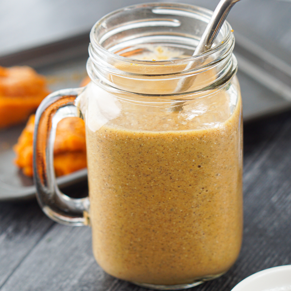 glass jar with a keto protein pumpkin smoothie and a steel straw