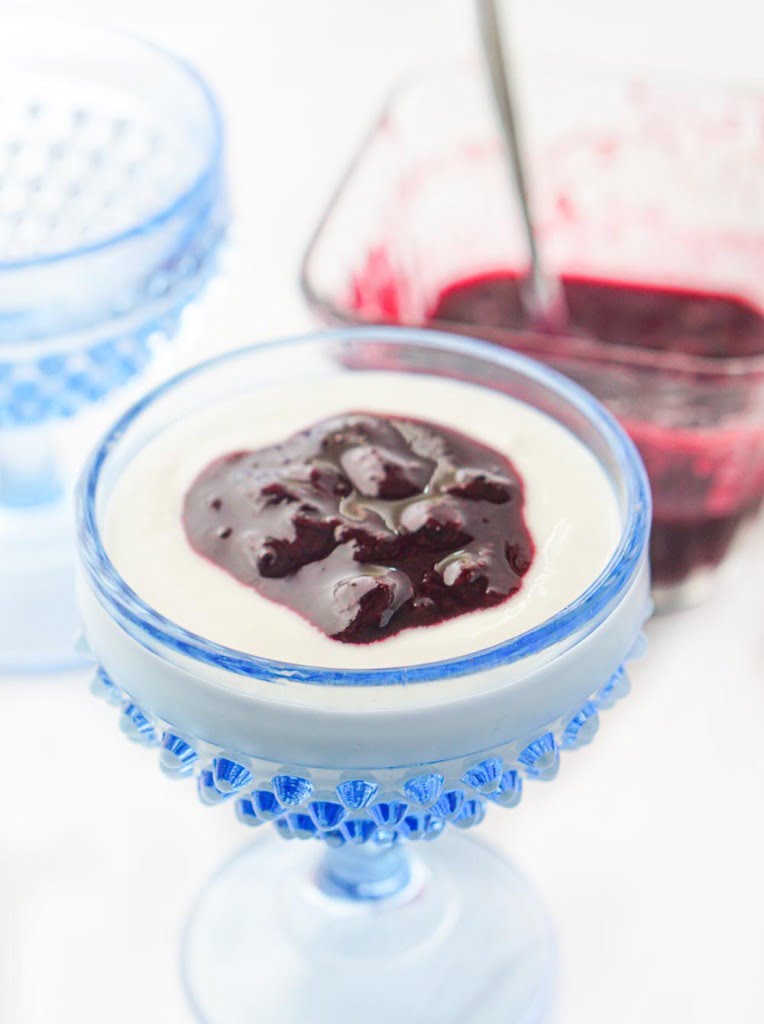 blue glass dessert dish with yogurt and sugar free blueberry sauce on top