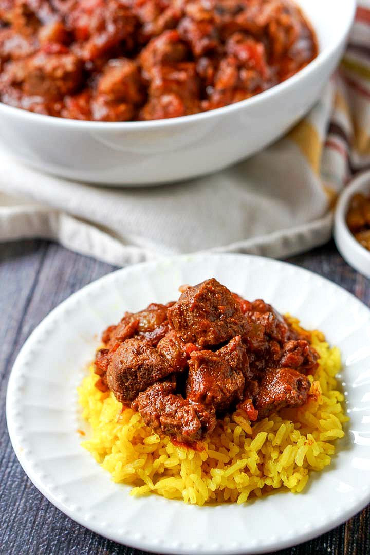 white plate with yellow rice and easy beef curry and bowl in background