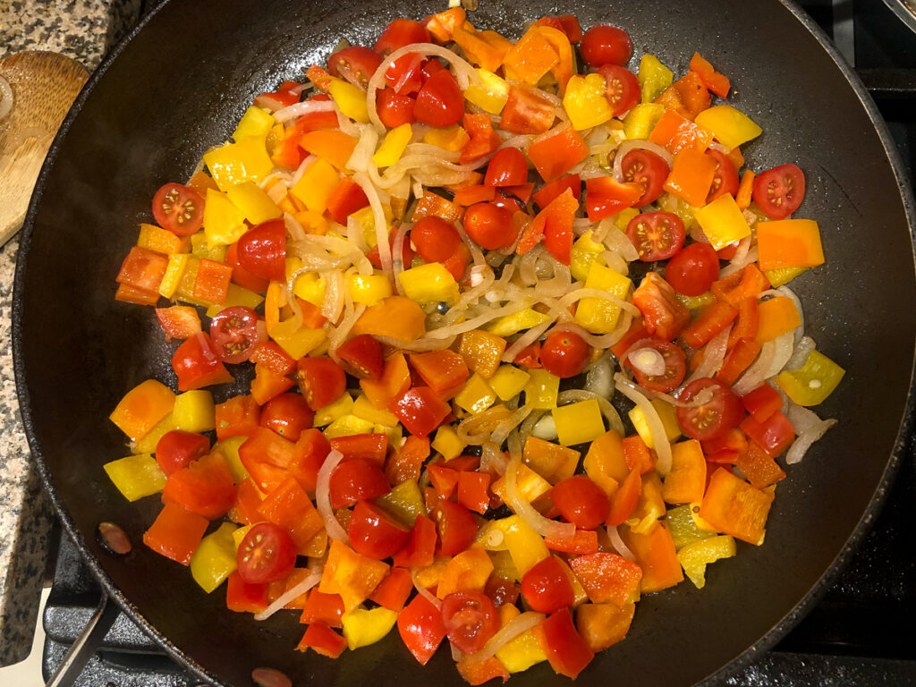 pan with sauted peppers onions and tomatoes