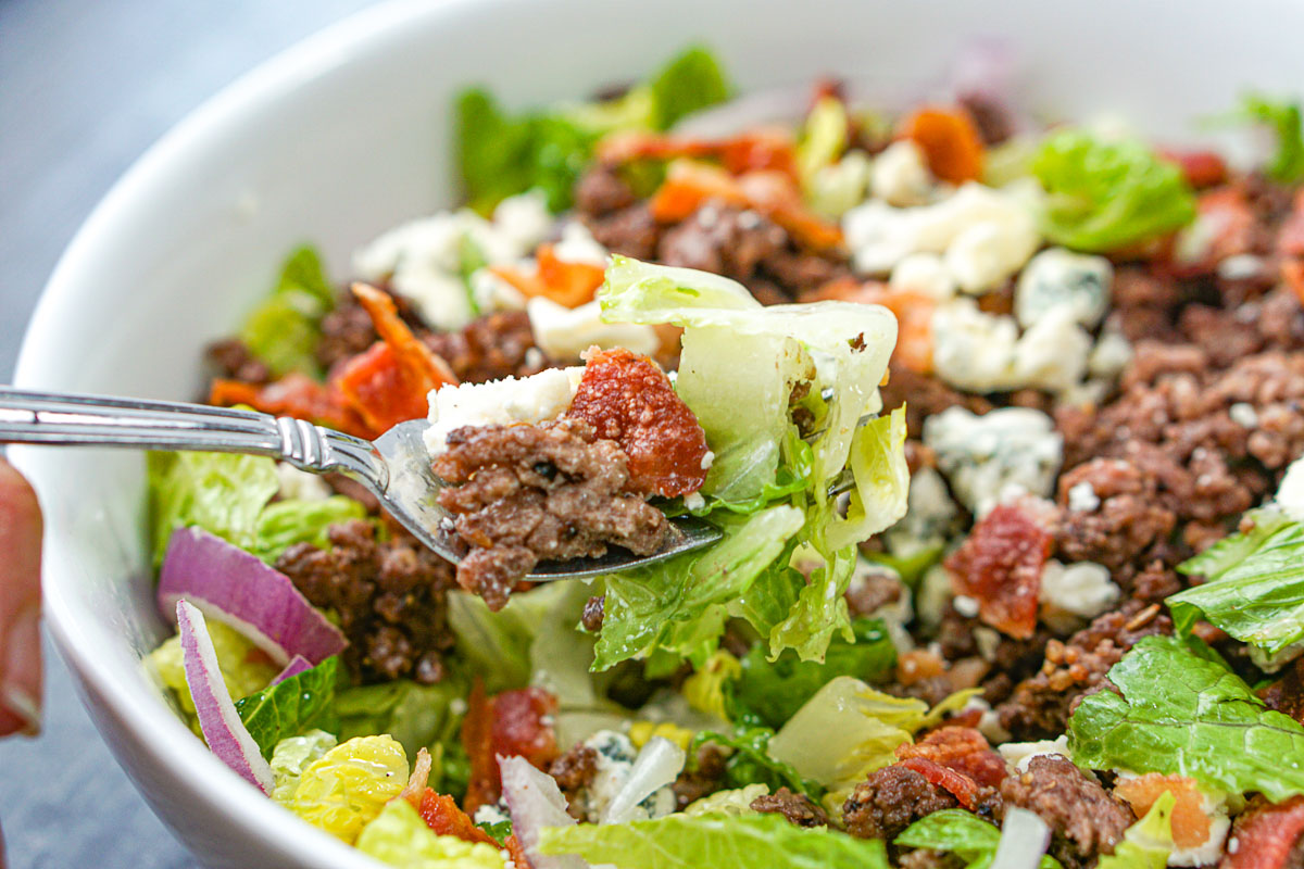 closeup of a forkful of cheeseburger salad