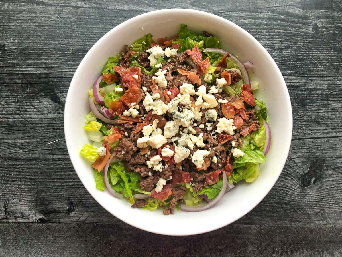 white bowl with finished bacon blue cheese burger salad