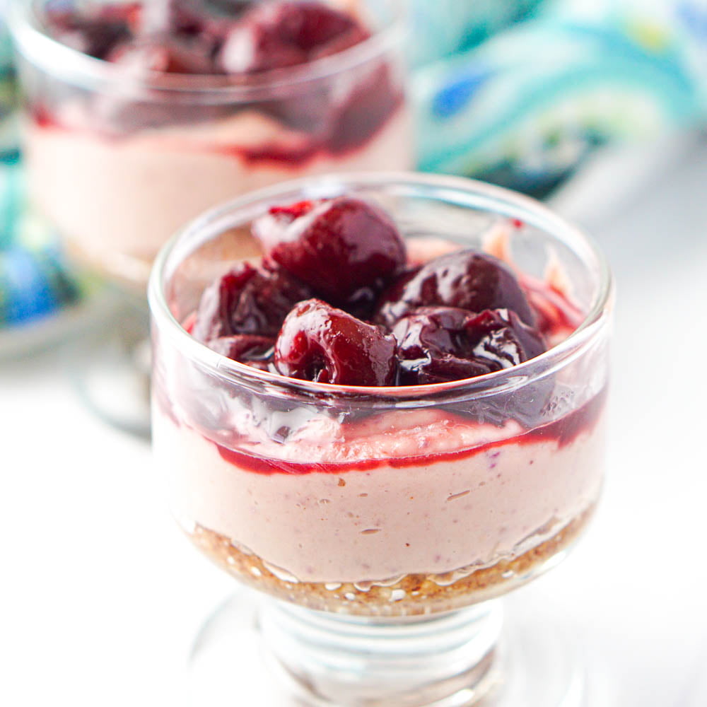 closeup of glass cup with cherry dairy free cheesecake treats