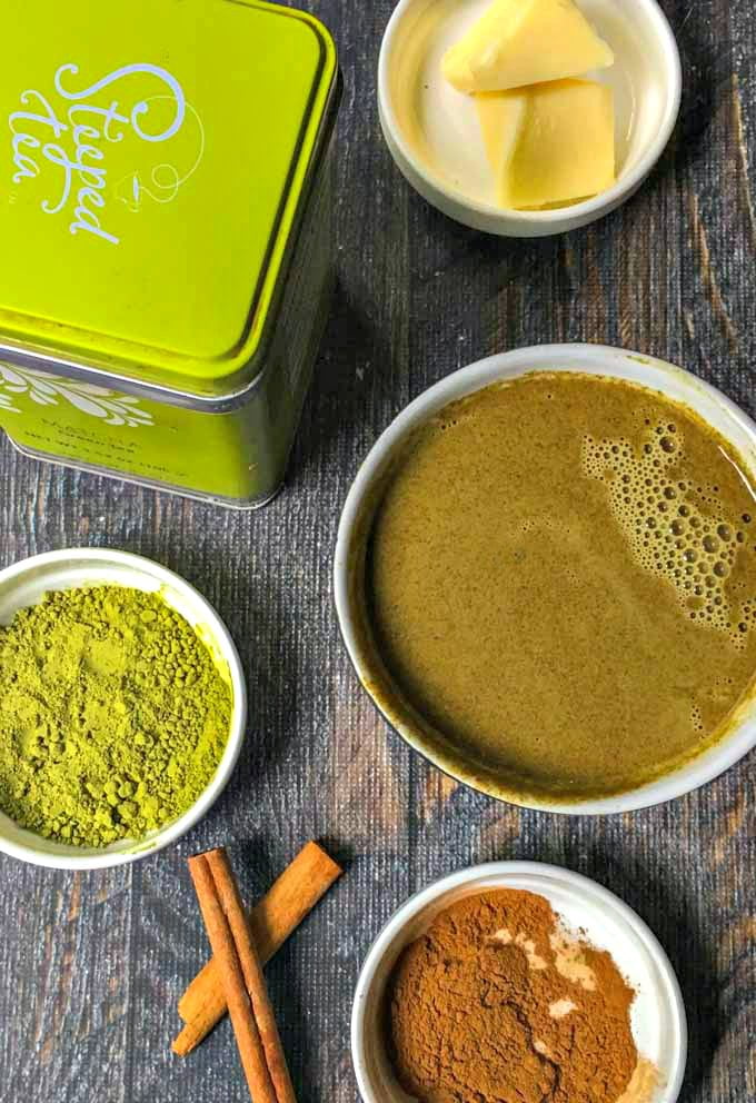 green matcha canister and white dishes with matcha green tea powder, cinnamon, cinnamon sticks and butter