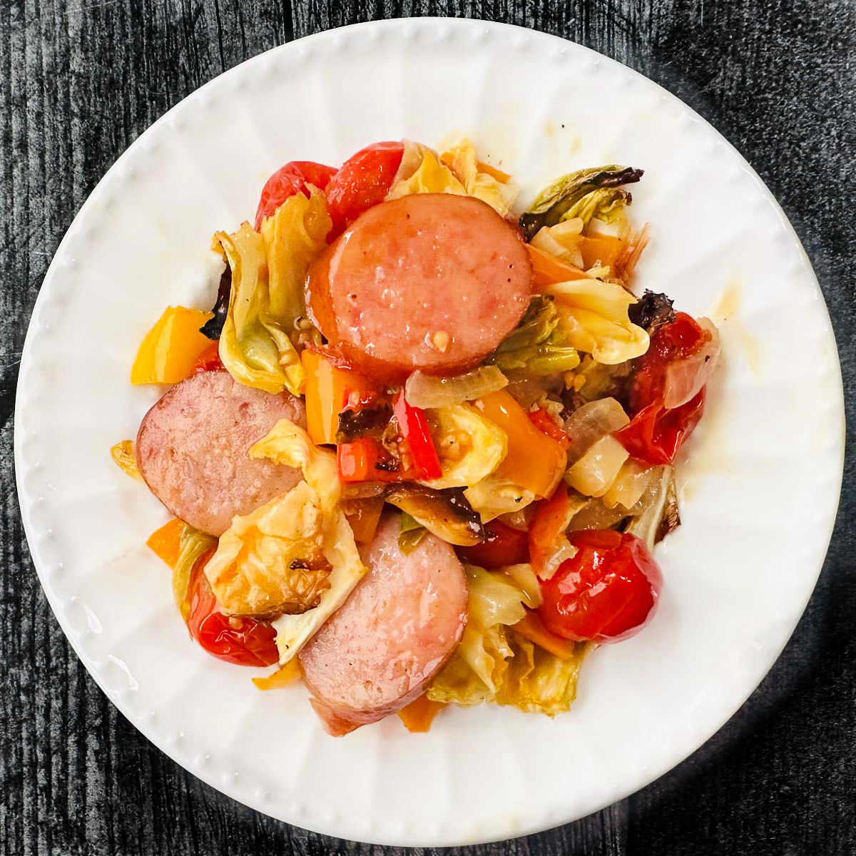 white plate with kielbasa and cabbage casserole