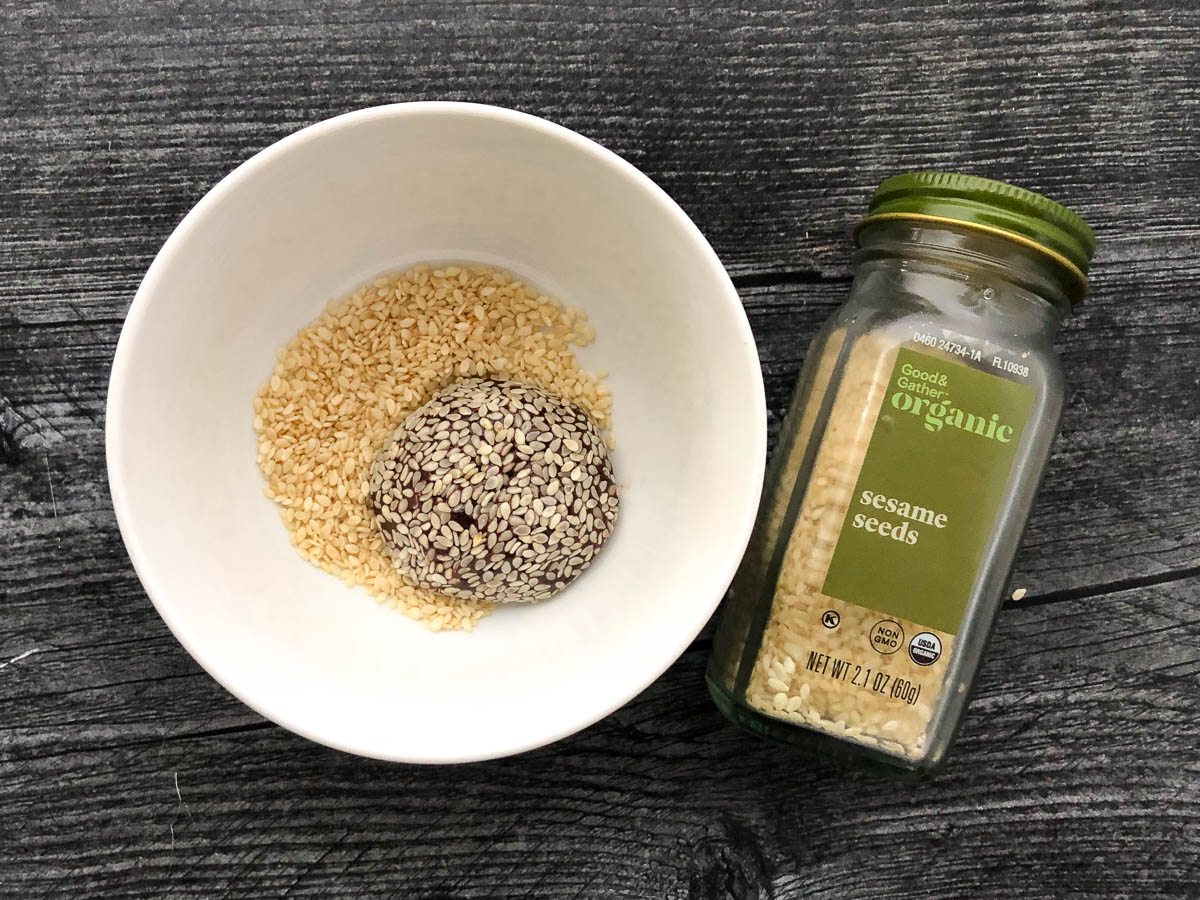 white bowl with sesame seeds and a jar