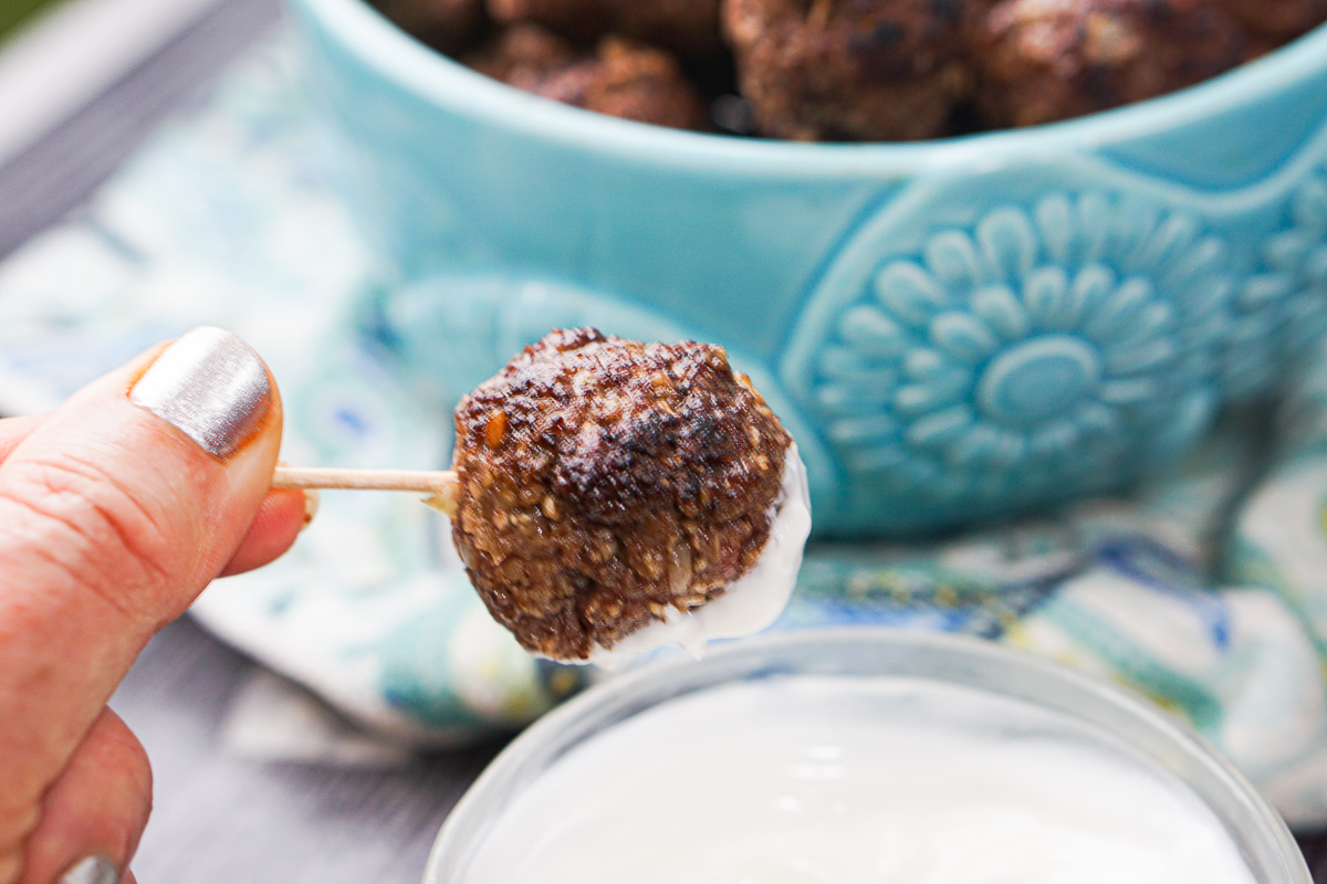 a meatball on a toothpick dipped in yogurt