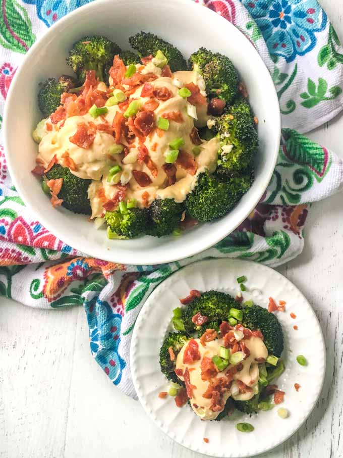 bowl of roasted broccoli with bacon and cauliflower cheese sauce