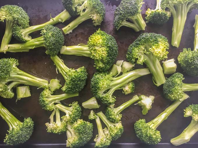 raw broccoli florets on cookie sheet