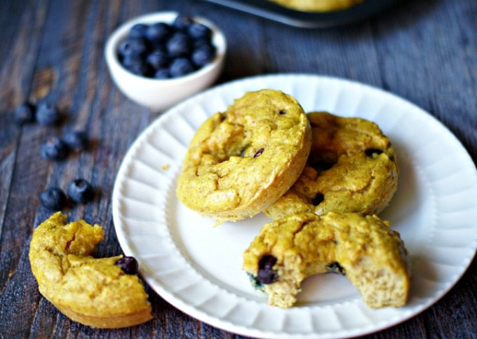 paleo  blueberry bagels on white plate with blueberries scattered