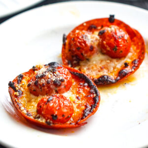 Closeup of a white plate with 2 keto pepperoni pizza bites.