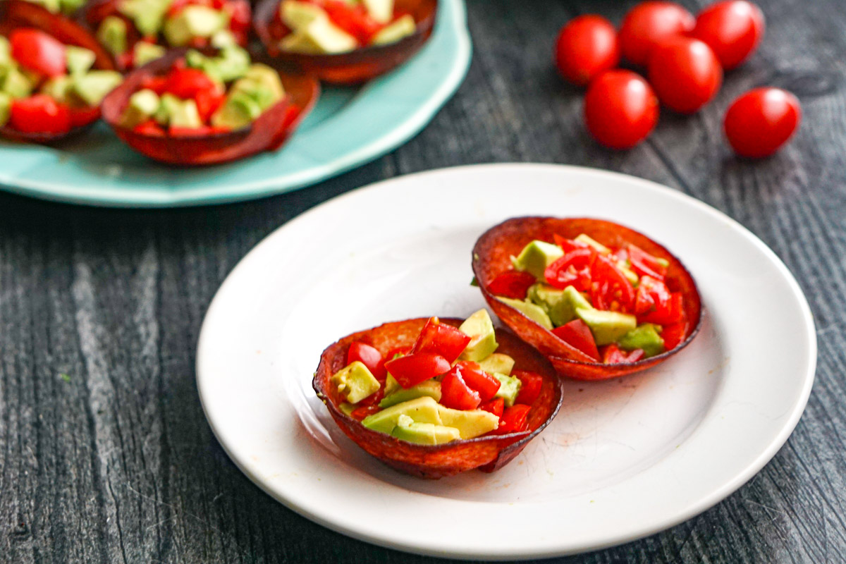 Closeup of a white plate with 2 of the finished recipe and scattered tomatoes in the background.