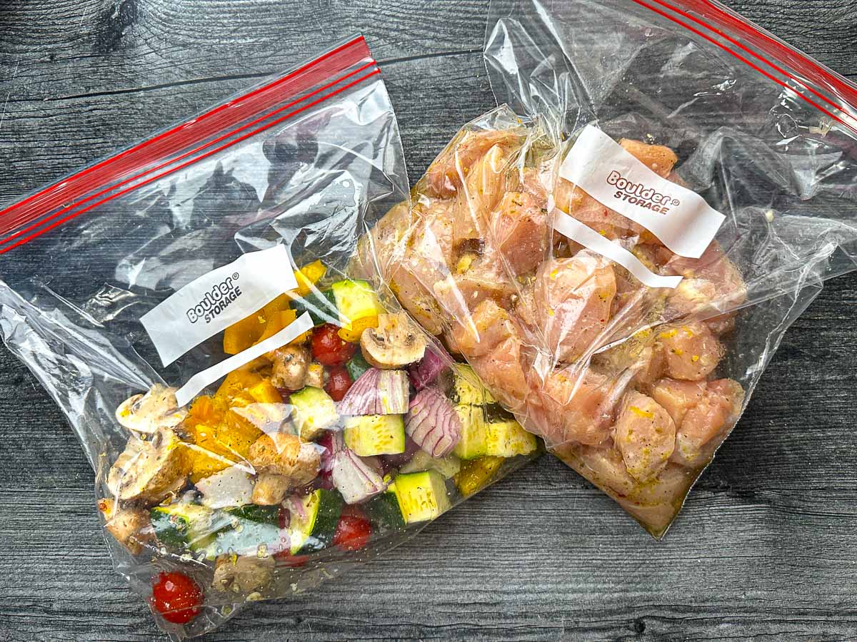 Two big ziplock bags - one filled with marinated chicken pieces and the other with marinated veggie pieces.