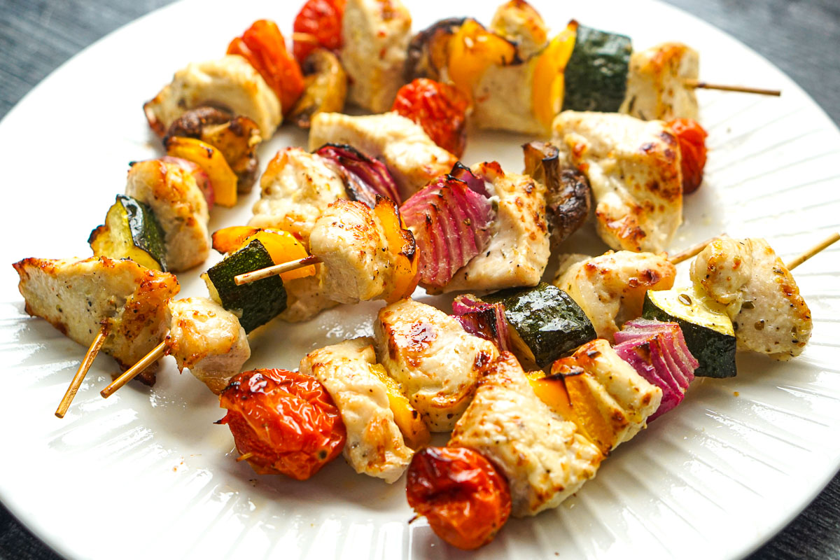 Closeup of a white plate with the finished Greek chicken kabobs.