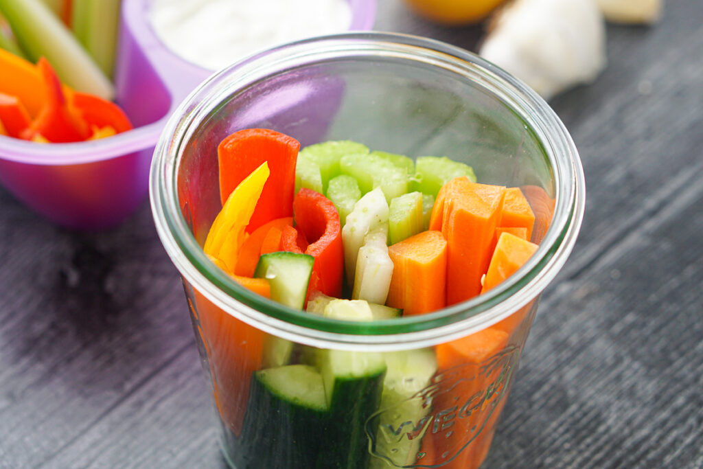 glass jar holding chopped fresh vegetables