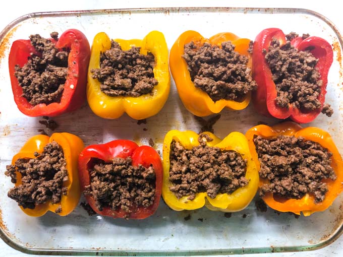baking dish with peppers stuffed with taco meat before baking