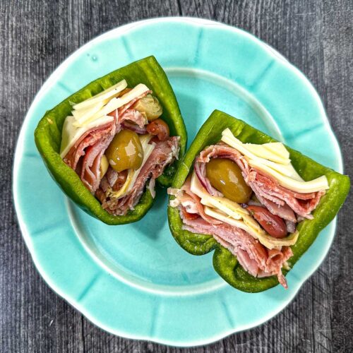 Aqua plate with an antipasto stuffed raw pepper cut in half.