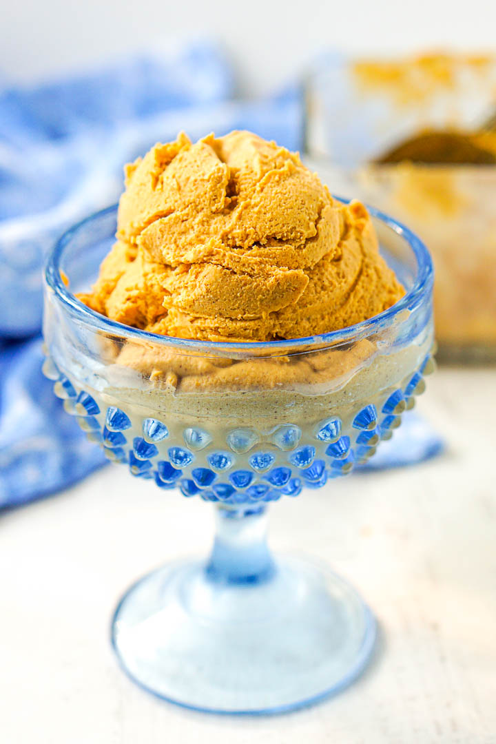 closeup of blue glass dish with a scoop of keto pumpkin blender ice cream