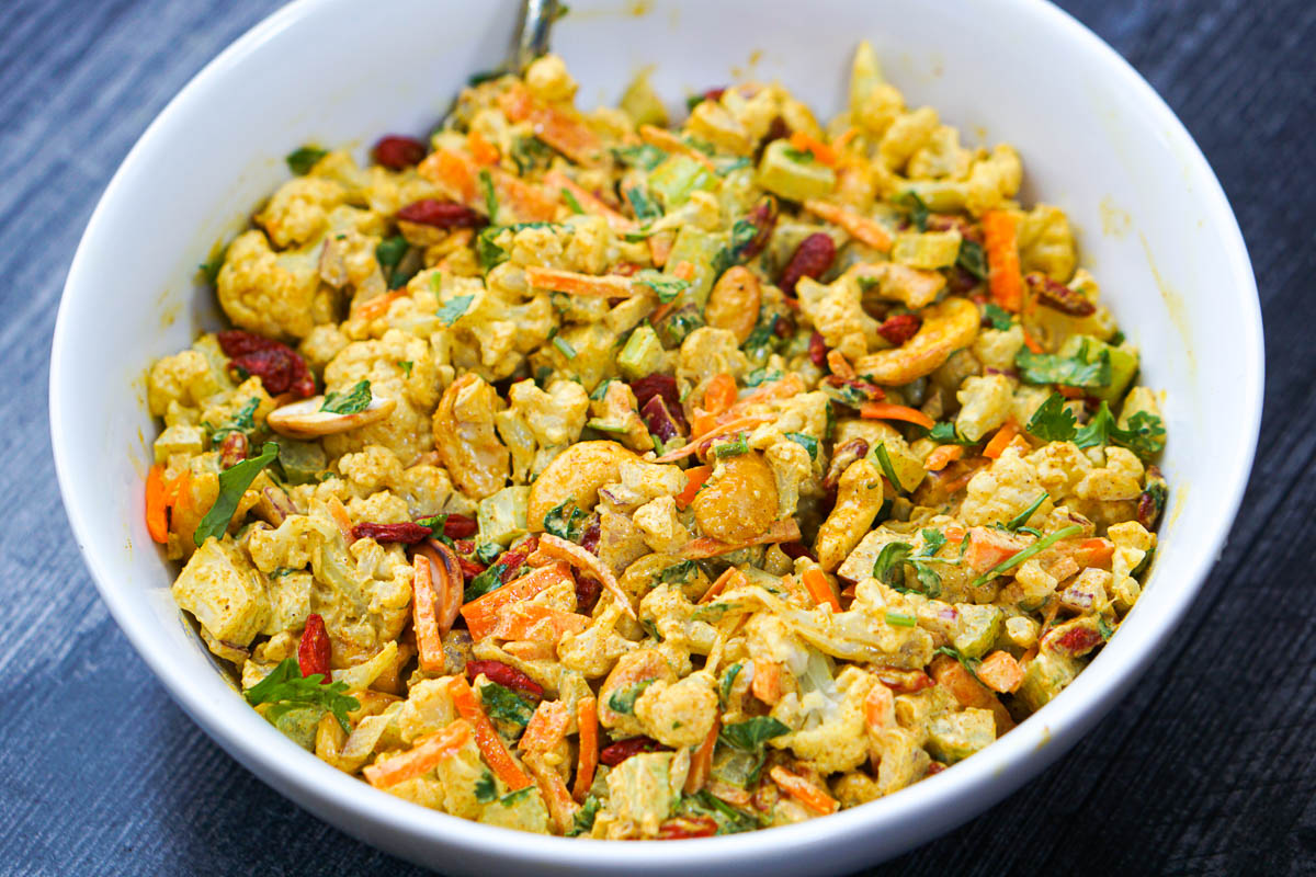 closeup of white bowl with curry vegetable salad