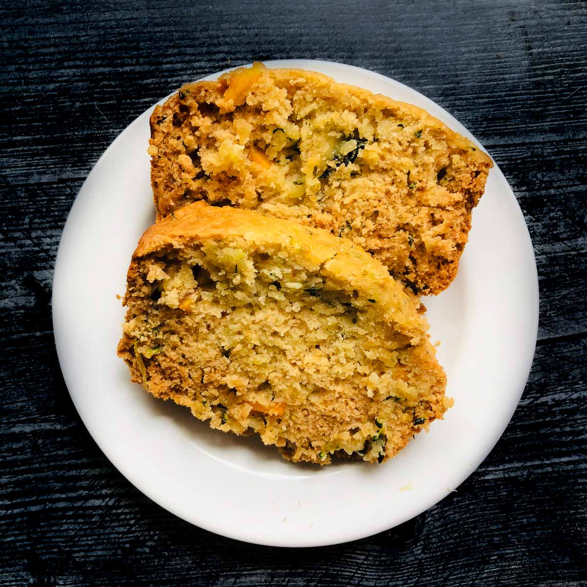 white plate with 2 slices of mango & honey zucchini bread