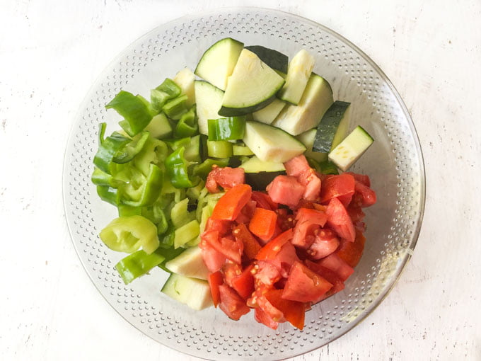 bowl with chopped zucchini, peppers and tomatoes from garden