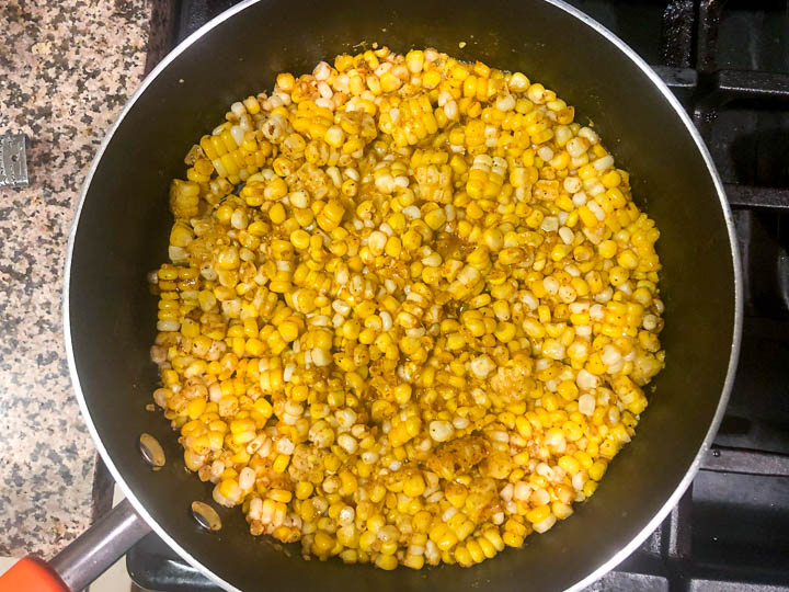 large pan on the stove with the corn and spices cooking