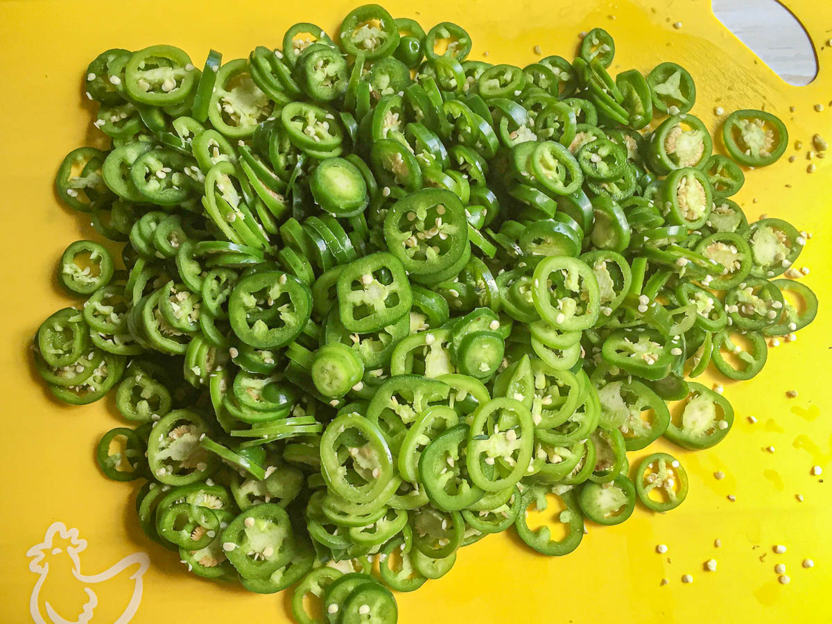 yellow cutting board with slices of jalapenos