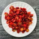 White plate with a bunch of homemade sun dried tomatoes.