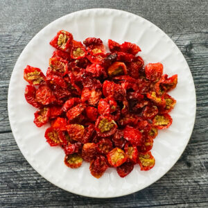 White plate with a bunch of homemade sun dried tomatoes.