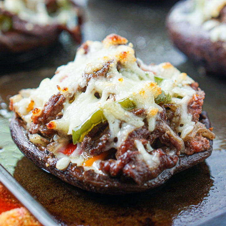 portobello mushroom cap filled with Philly cheesesteak on a tray