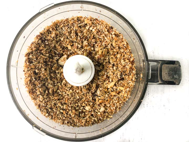food processor bowl with ground nuts and seeds