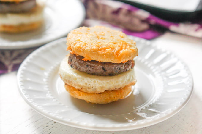 closeup of sausage & egg muffin on white plate