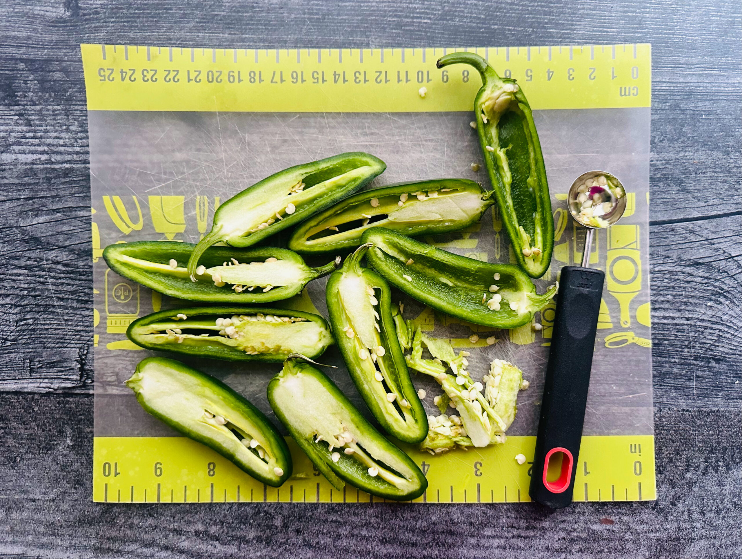 cut fresh jalapenos with a melon baller on cutting board