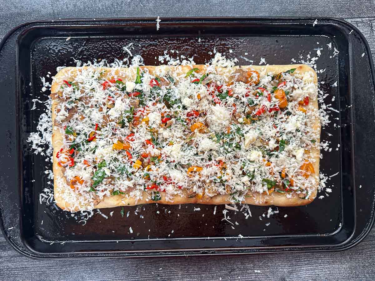 A baking sheet with the prepared pizza ready to bake.