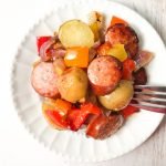 white plate with kielbasa, potatoes and peppers