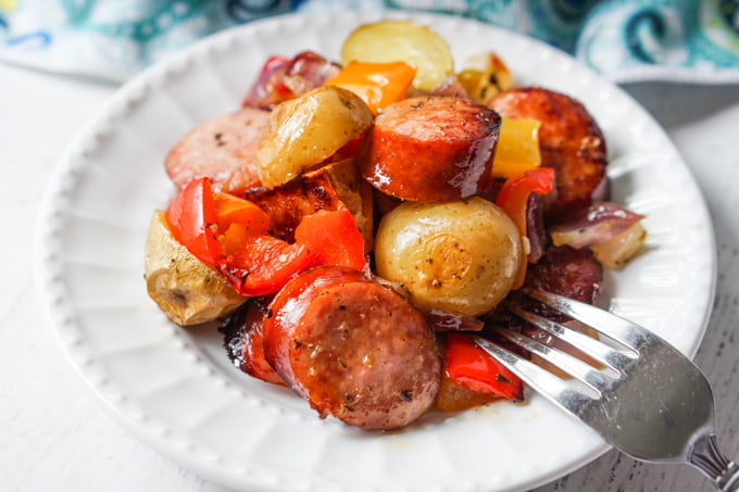 white plate with kielbasa, potatoes and peppers 