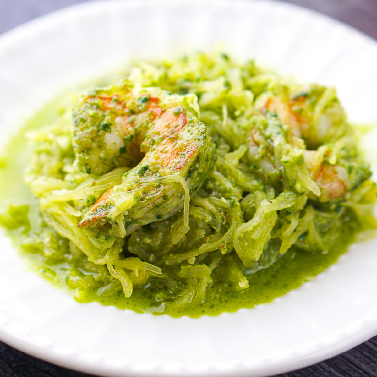 white dish with spaghetti squash and spinach pesto and shrimp