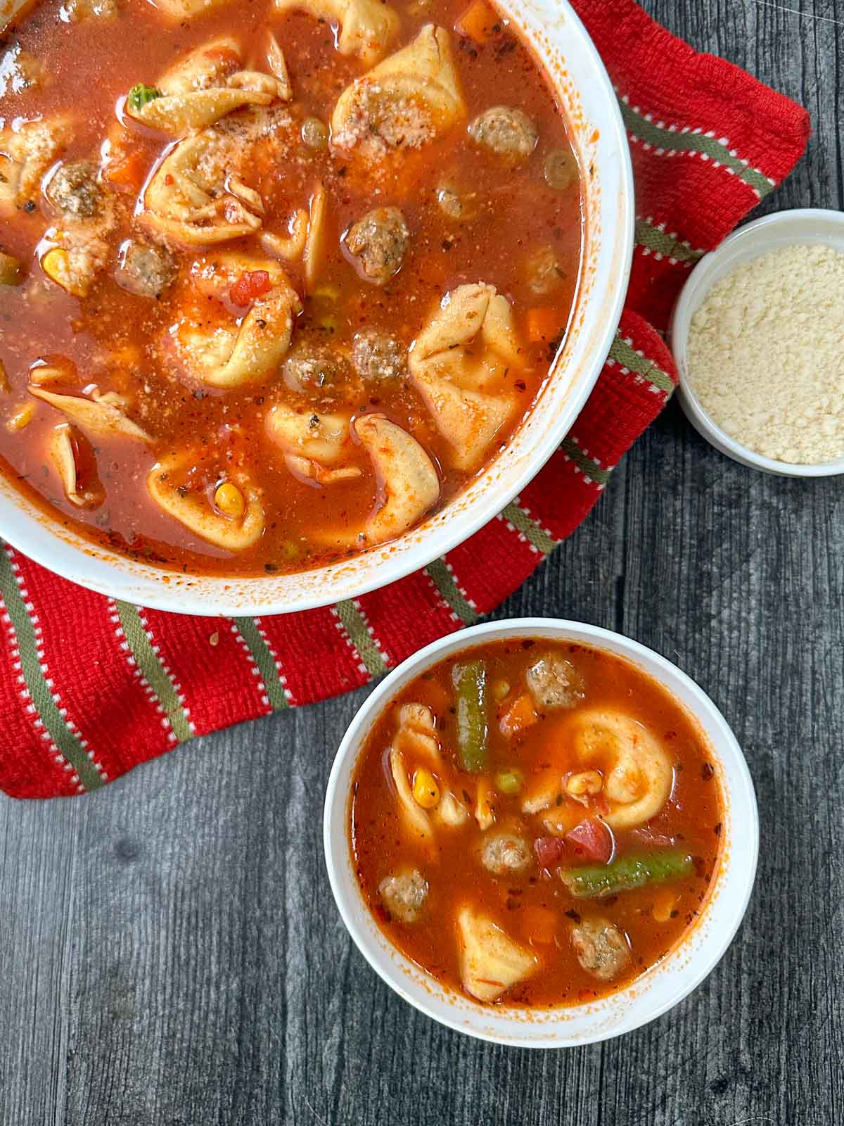 aerial view of Italian tortellini soup with meatballs and grate cheese