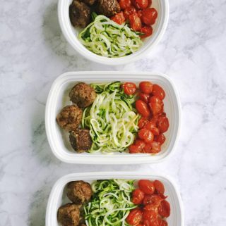 Paleo meatballs go great with roasted grape tomatoes and zucchini noodles to make a healthy freezable lunch. Save time and stay on track with this simple and easy meal.