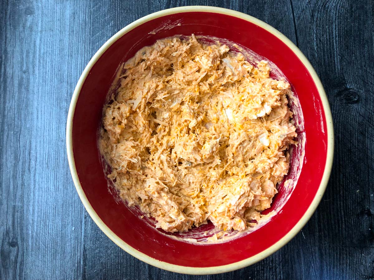 red bowl with unbaked buffalo dip