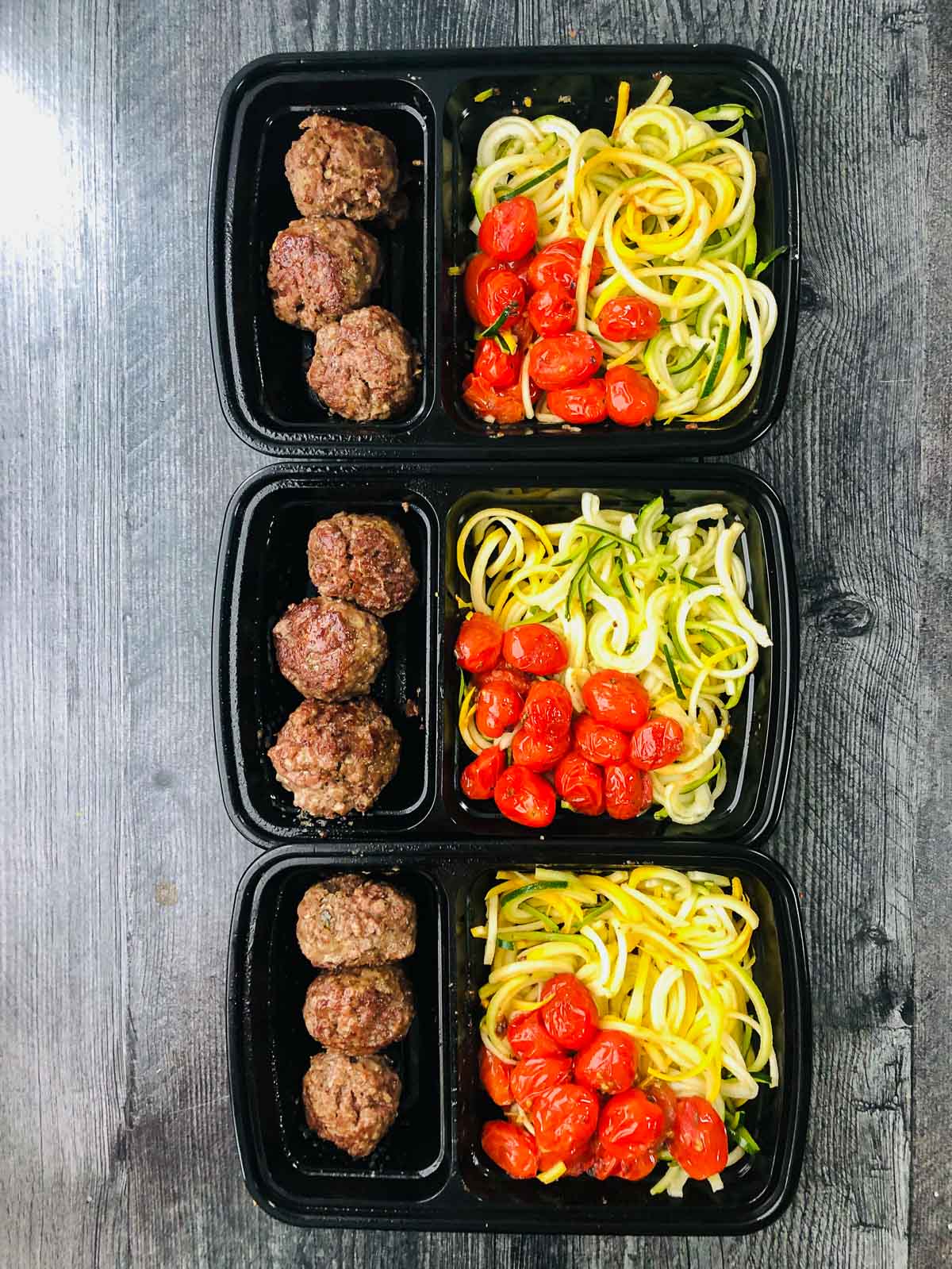 3 black freezer containers with homemade microwave freezer lunches